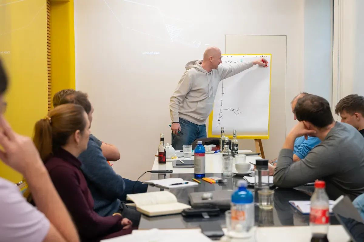 A facilitator working through sticky notes with engineering leaders in a workshop