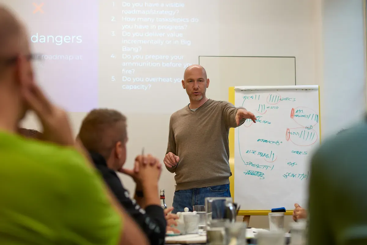 Marian Kamenistak presenting to senior engineering leaders in a warm-lit room