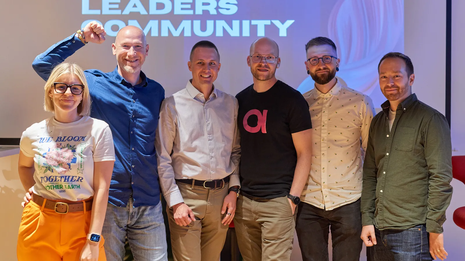Speakers on stage in front of the Engineering Leaders Community wall