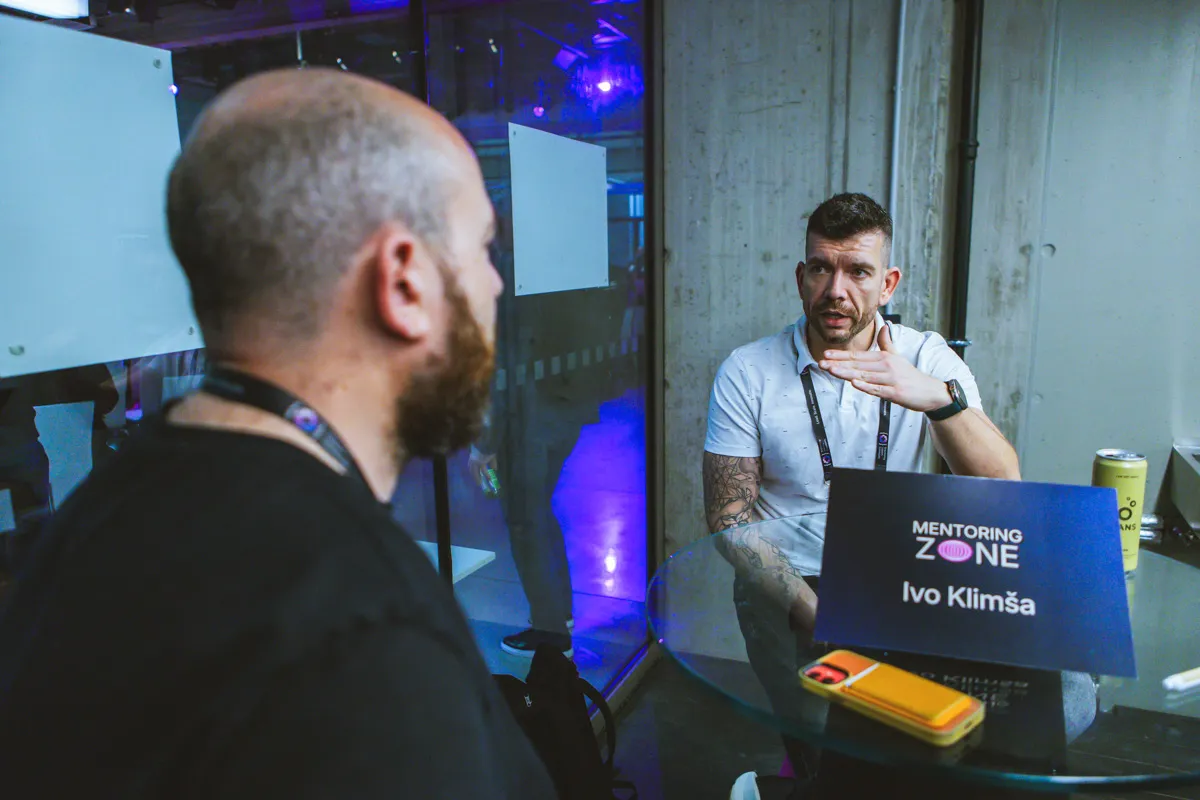 Two engineering leaders in a one-on-one conversation at a glass table under a Mentoring Zone sign at the ELC Conference.