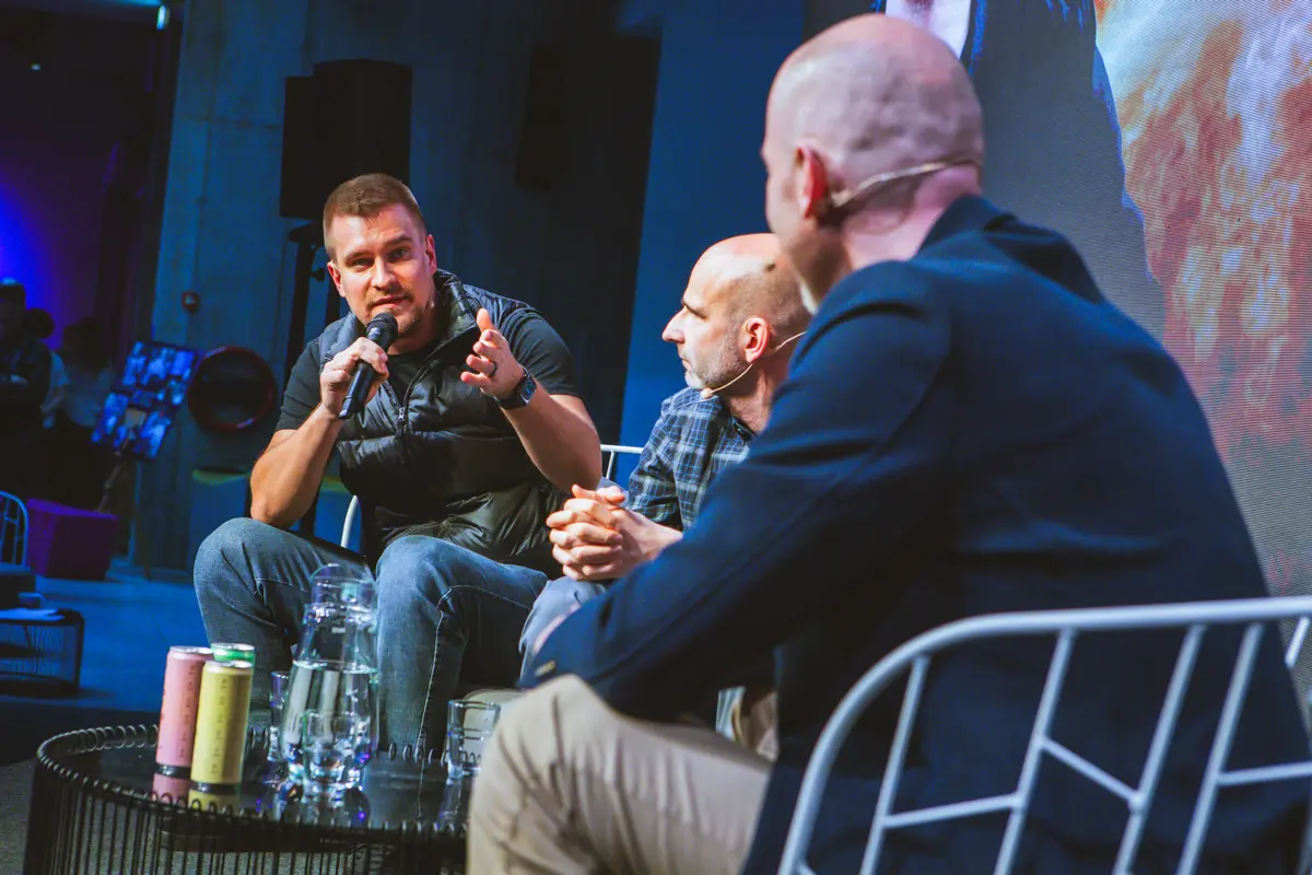 Three engineering leaders on a panel at the ELC conference, one speaking into a microphone, the level that owns budget and the AI roadmap